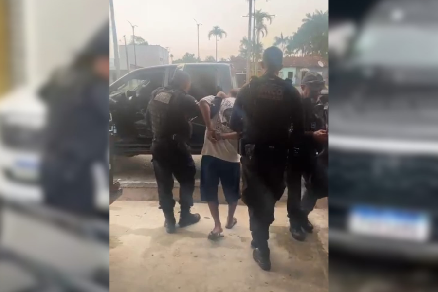 Imagem do suspeito sendo conduzido até a delegacia pelos agentes da polícia civil.
