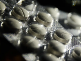 Imagem em close de uma cartela de pílulas de remédios brancos.