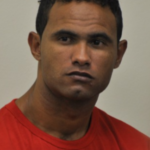 Na imagem o goleiro Bruno Fernandes aparece sentado durante o seu julgamento usando uma blusa laranjada.