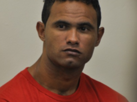 Na imagem o goleiro Bruno Fernandes aparece sentado durante o seu julgamento usando uma blusa laranjada.