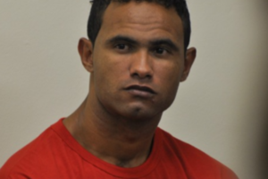 Na imagem o goleiro Bruno Fernandes aparece sentado durante o seu julgamento usando uma blusa laranjada.