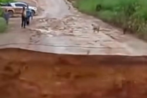 A imagem mostra um trecho de uma estrada de lama após o desabamento.