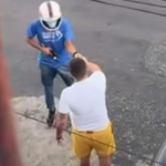 Na imagem o suspeito usando capacete e armado aborda a vítima no meio da rua.