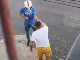 Na imagem o suspeito usando capacete e armado aborda a vítima no meio da rua.