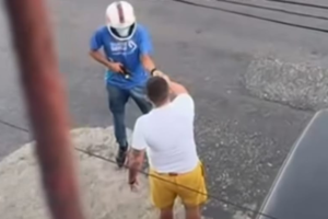 Na imagem o suspeito usando capacete e armado aborda a vítima no meio da rua.