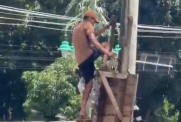 Homem em cima de escada danificando a câmera