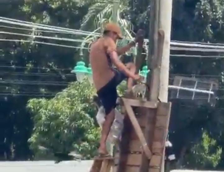 Homem em cima de escada danificando a câmera