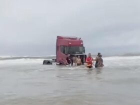 Caminhão atolado na água do mar.