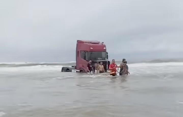 Caminhão atolado na água do mar.