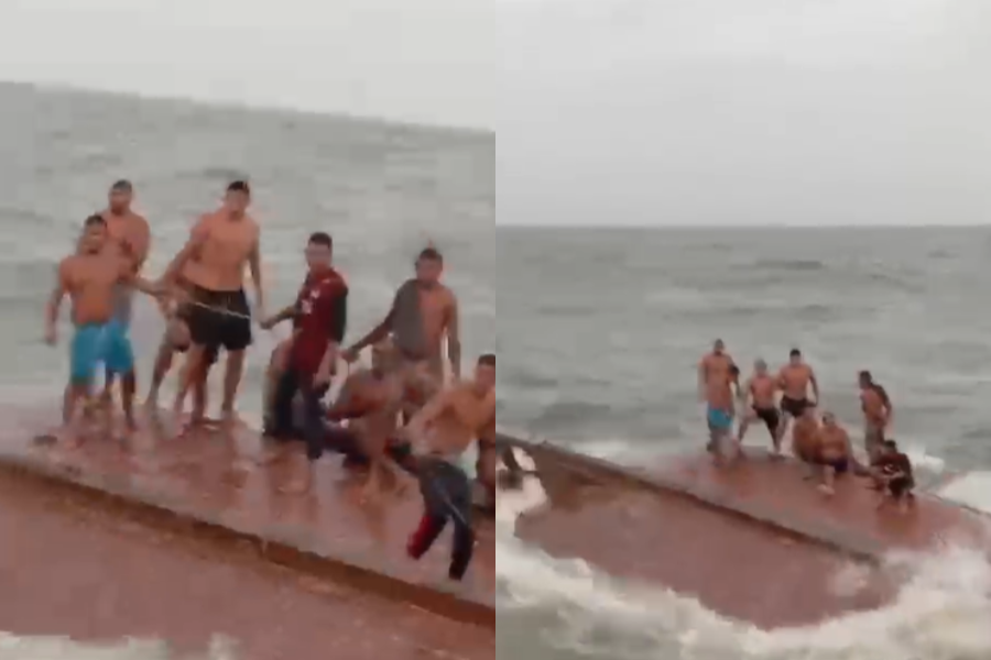 Paasageiros em cima do barco virado, aguardando resgate