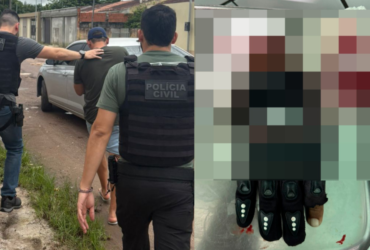 homem sendo conduzido por policiais