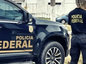 Imagem ilustrativa de agente da Polícia Federal ao lado de viatura