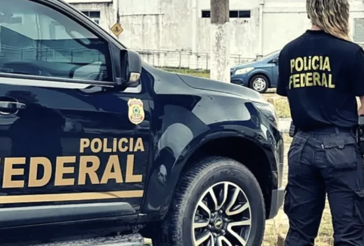 Imagem ilustrativa de agente da Polícia Federal ao lado de viatura