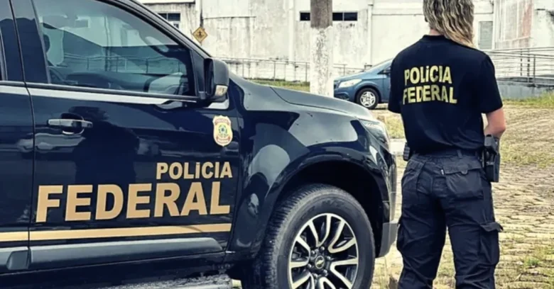 Imagem ilustrativa de agente da Polícia Federal ao lado de viatura