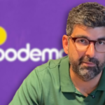 Dr. Daniel. No fundo, imagem da logo do Podemos