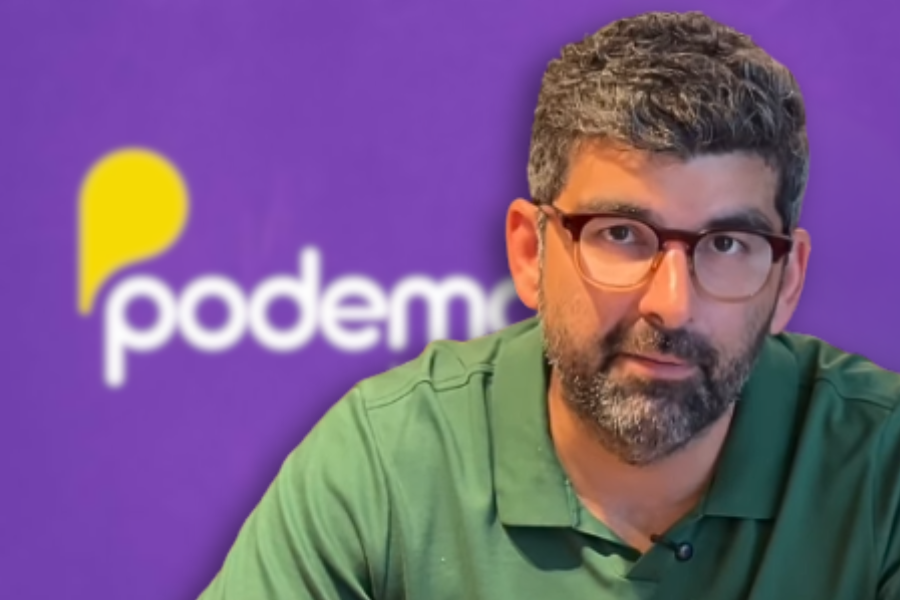 Dr. Daniel. No fundo, imagem da logo do Podemos