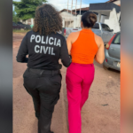 Mulher sendo conduzida pela polícia