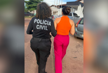 Mulher sendo conduzida pela polícia