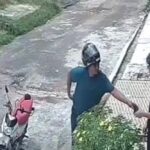 Assaltante aborda o jovem na calçada durante o assalto.