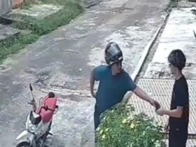 Assaltante aborda o jovem na calçada durante o assalto.