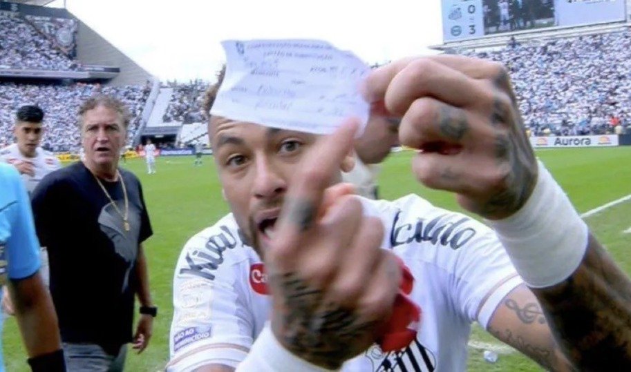 Neymar mostrando o papel utilizado na substituição no meio da partida.