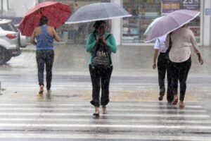 Pessoas enfrentando chuva forte em Belém