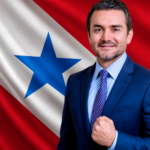 Foto de Celso Sabino com a foto da bandeira do Pará ao fundo