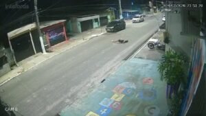 Acidente foi registrado por câmeras de segurança; vítima de 24 anos bateu a cabeça no asfalto e permanece internada após a queda.